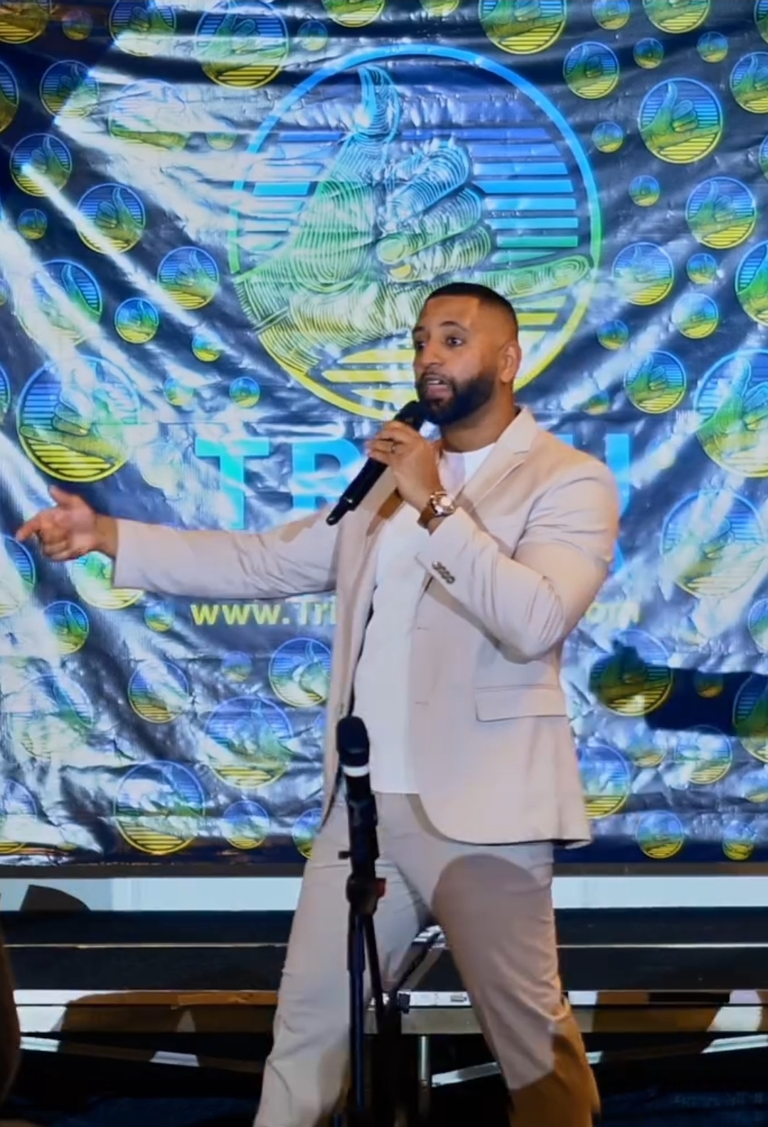 Jose Bernard speaking on stage in front of the Tribu Pura Vida backdrop
