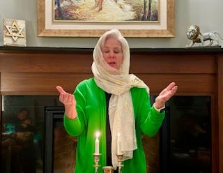 Marcia Berkowitz lighting a candle