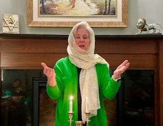 Marcia Berkowitz lighting a candle
